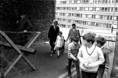 Londonderry: Sonntagfrüh, katholische Familie nach dem Gottesdienst in Bogside, vorbei an Spanischen Reitern und Soldaten mit dem Gewehr im Anschlag